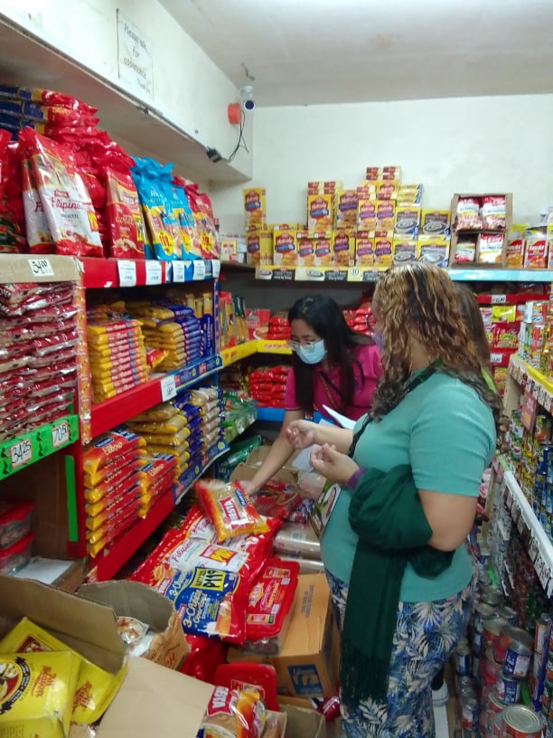 in photo: Price Monitors inspecting a noche buena package