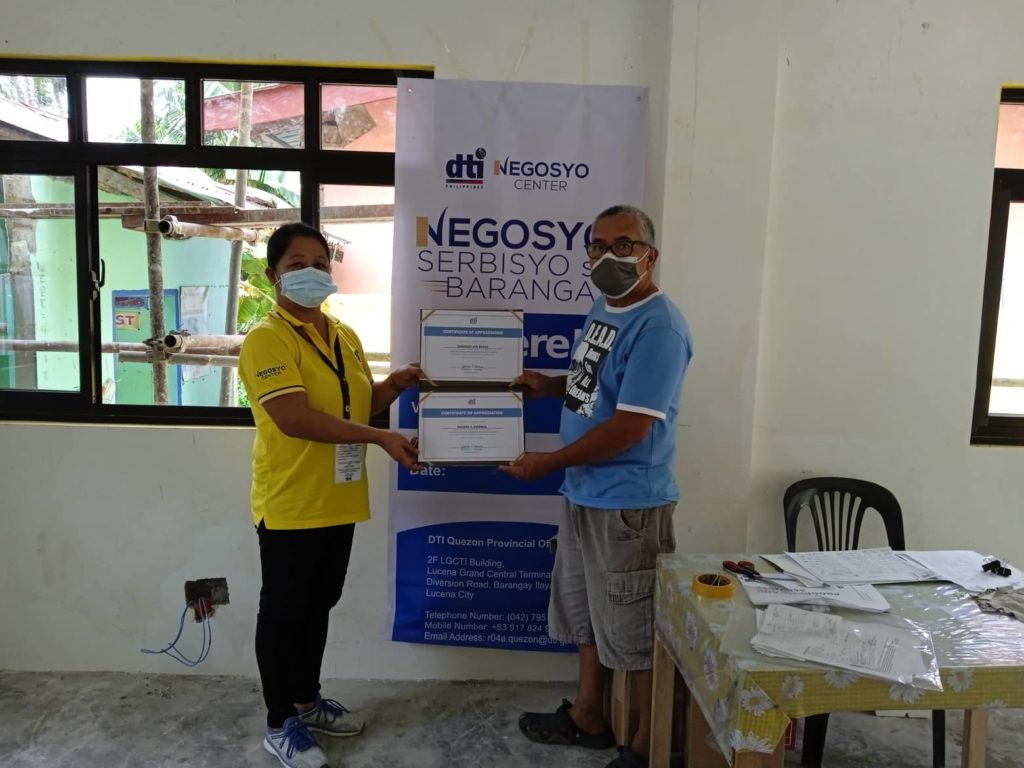 In Photo: Negosyo Center Business Counselor and LSP-NSB beneficiary holding a certificate