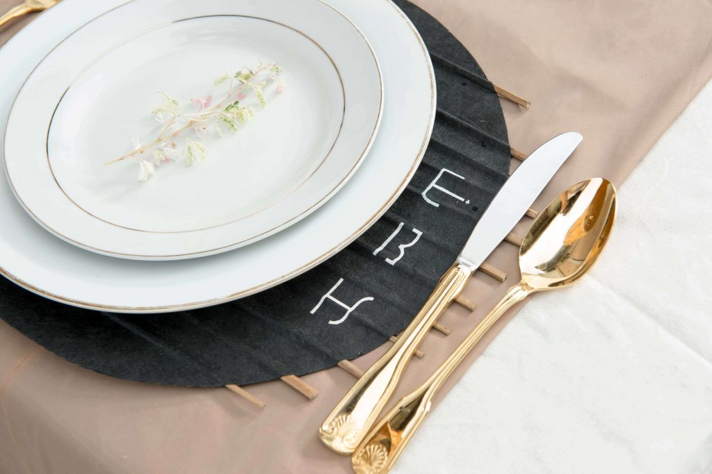 A classic dishware set placed on the charcoal colored paper placemat