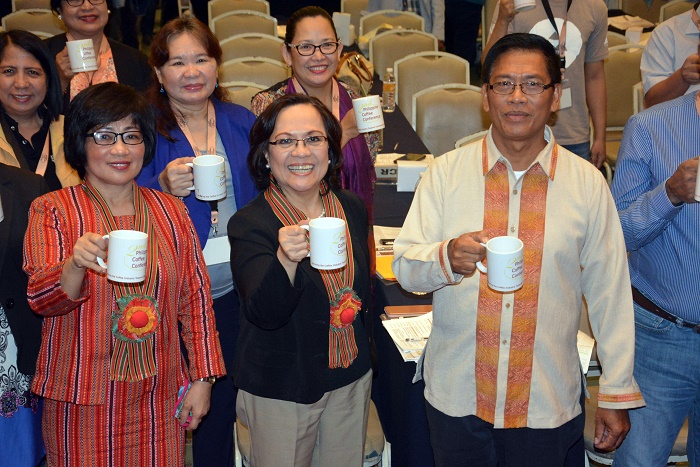 DTI-Cordillera Administrative Region (DTI-CAR) Regional Director Myrna P. Pablo. DTI-Regional Operations Group Undersecretary Zenaida Maglaya and Department of Agriculture-CAR's Regional Director Lorenzo Carangian raises their mugs leading 800 others during the 2nd Philippine Coffee Conference for the success of the Philippine coffee industry.